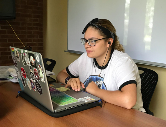 unior Mercedes Steele listens to music on her laptop while doing work for her classes. Photo by Emmalyn Ylaya.