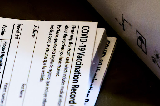 A stack of vaccination cards waits to be filled for the recipients records.