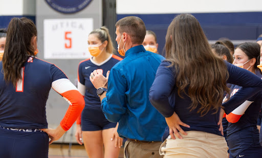 Womens Volleyball Head Coach Josh Higby discusses strategy with players during a home game.