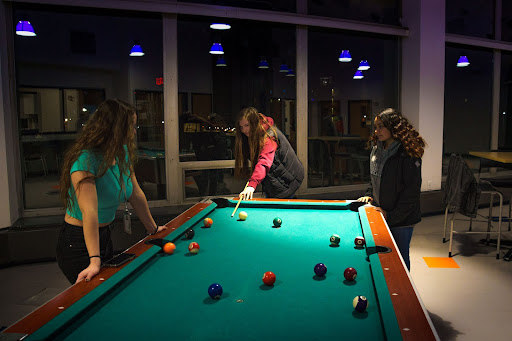 From left, Leola Beck 25, Karrie Kosier 25 and Lila Vega 25 during their nightly game of pool.
If commuter students want this part of the college experience, they should be able to experience it, Beck said.
