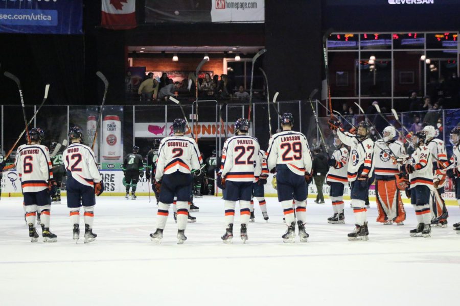 Utica University mens ice hockey team celebrates a win at center ice.