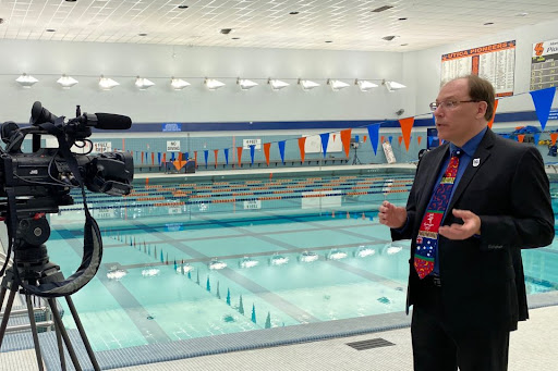 Paul J. MacArthur being interviewed next to the Utica University pool about the Olympics.