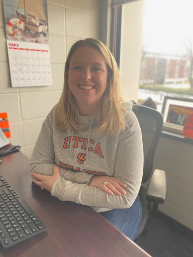 Devlin Daley showing off her Utica spirit in her new office located in 206 Strebel Student Center.
