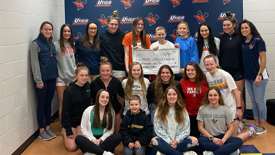 Utica University’s women’s soccer team with a check for $6,000 to send Team IMPACT teammate Arianna “Anna” LaBella to Disney World.