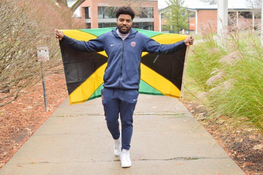 Antwan Kelly approaches the Strebel student center walking proudly with the Jamaican flag.