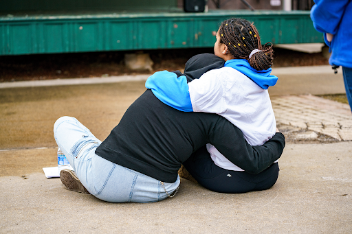 Two people on the ground hugging each other. // Courtesy of The Tangerines photo file
