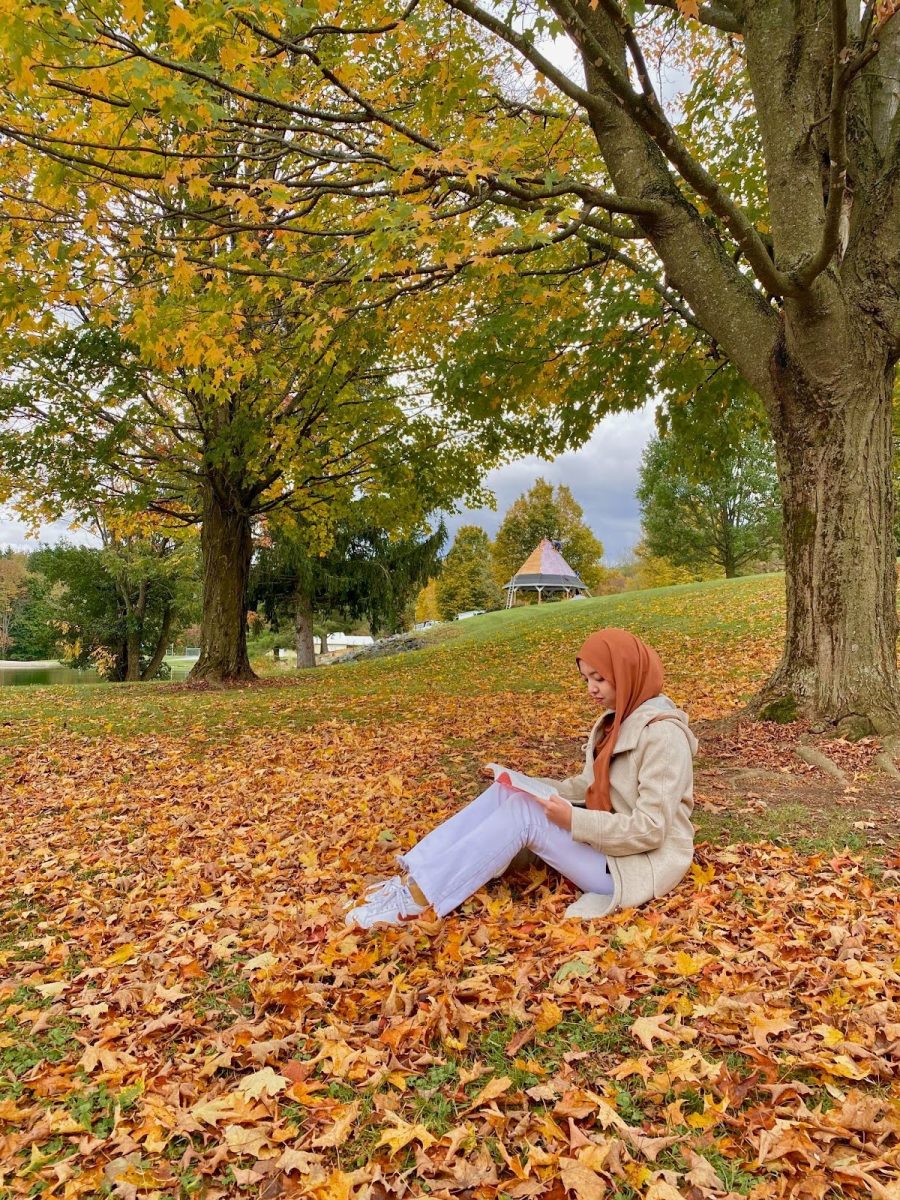 Syamimi Anuar reads while sitting among the colorful leaves. /Photo courtesy of Syamimi Anuar