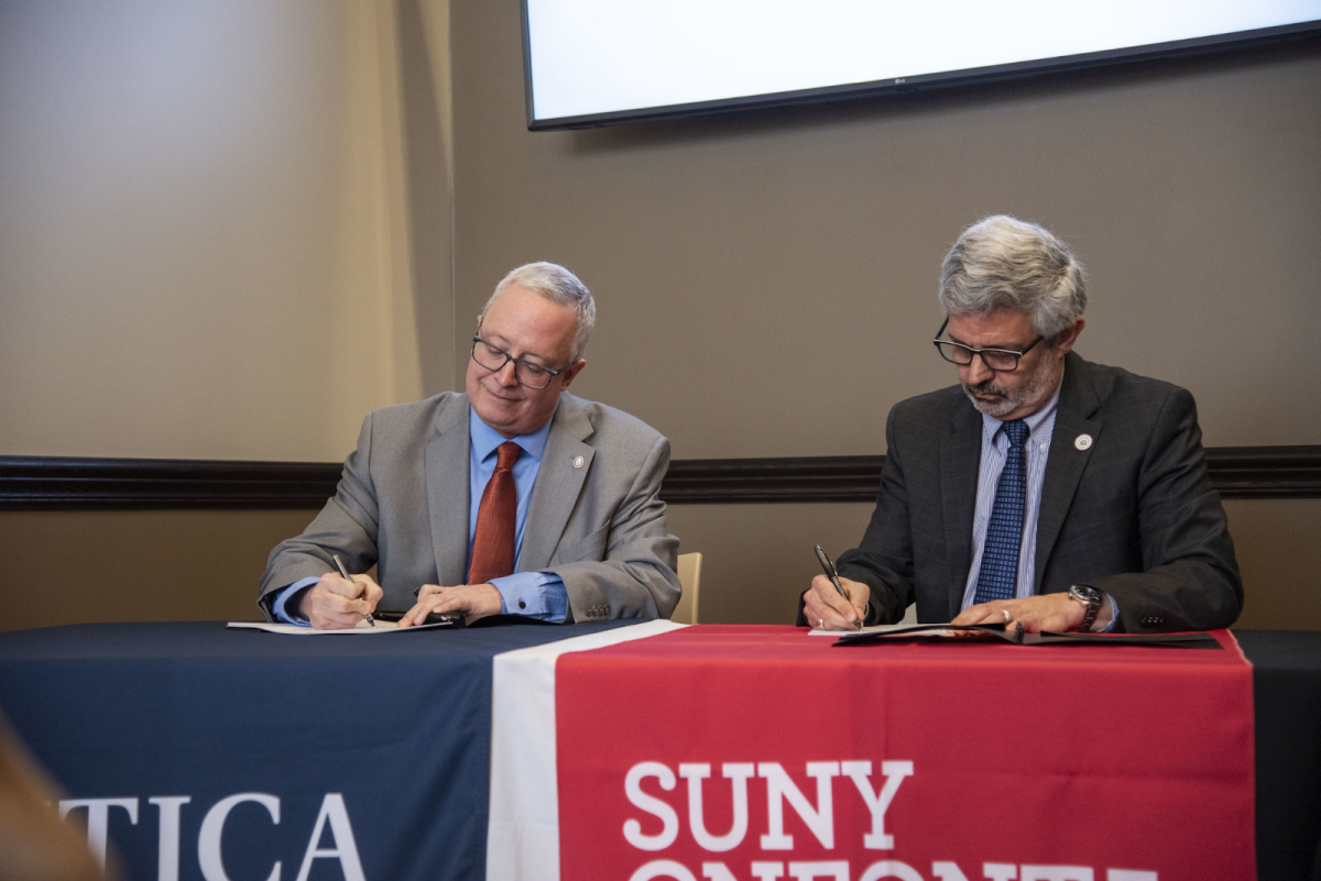 Utica President Todd Pfannestiel and SUNY Oneonta President Alberto Cardelle signing the ABSN agreement. /Photo courtesy of Adrienne Smith