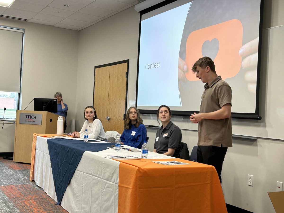 Brady Barnard, standing, speaks during a student panel at High School Communication Career Day on March 20. Other students from left to right are Grace Monaco, Diana Sidorevich and Corrine Bush. Seated at the computer is Patricia Swann, professor of Public Relations and Management. Photo: Mary Christopher