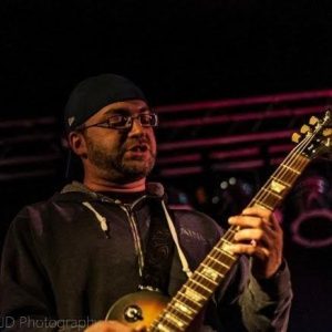 Jame Ostinett playing guitar. Photo taken from James Ostinett’s LinkedIn page. 